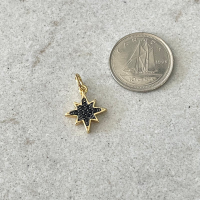 Gold star charm paved with black zircons
